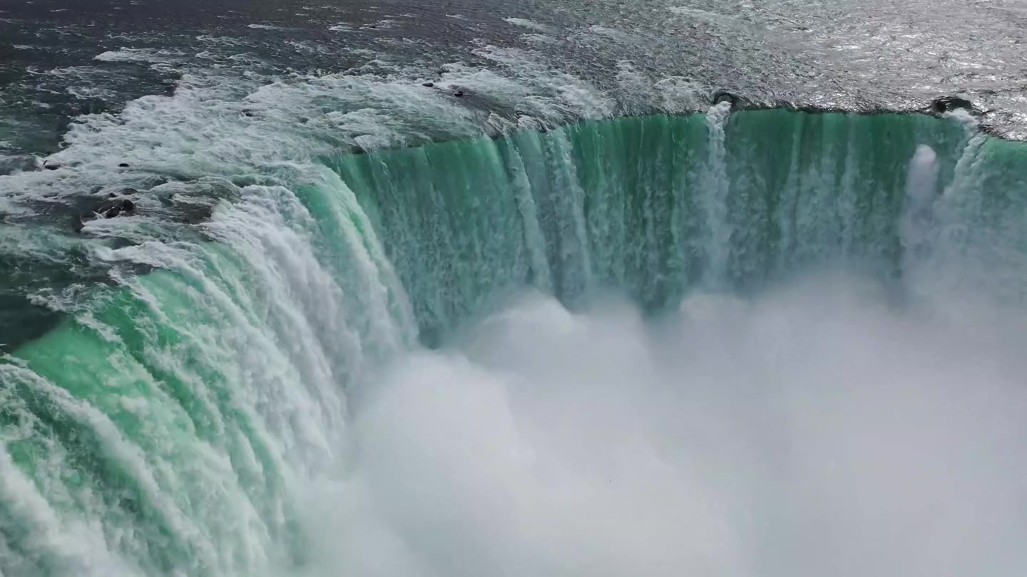 Turquoise water spilling over Horseshoe Falls into the mist